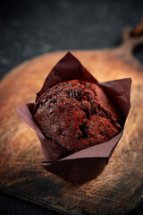 Chocolate muffin with chocolate pieces on a wooden board