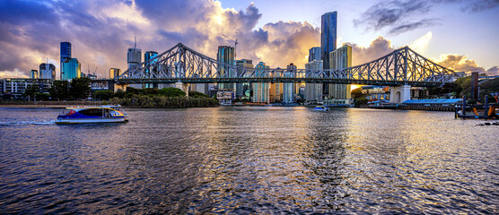 Brisbane city skyline at dusk with Storey Bridge and ferry  in foreground