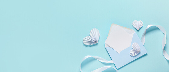 Composition with envelope and paper hearts on light blue background with space for text....