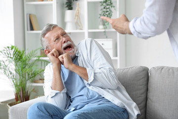 Senior man scared of his angry son at home - obrazy, fototapety, plakaty