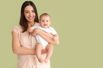 Happy mother with her little baby on green background