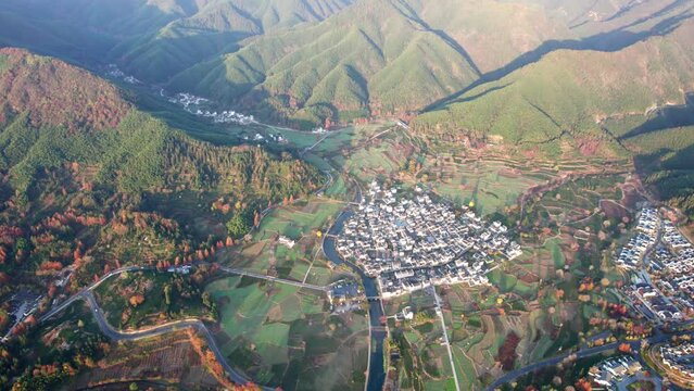 Aerial view of Chinese ancient village, Lucun, Hongcun, Anhui, China. Drone fly view of traditional villages in sunny autumn morning, sunrise time, colorful autumn forest, 4k real time footage.