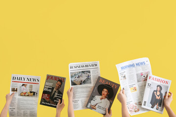 Women with newspapers and magazines on yellow background - obrazy, fototapety, plakaty