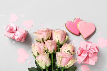 Bouquet of roses, gift boxes and heart-shaped cookies on grey background. Valentine's Day...