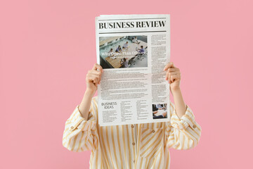 Young woman with newspaper on pink background - obrazy, fototapety, plakaty