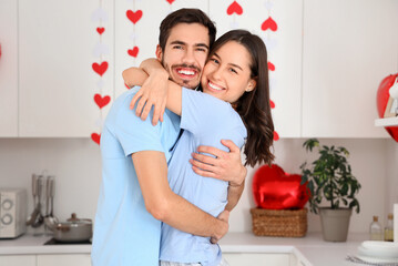 Happy young couple hugging in kitchen on Valentine's Day