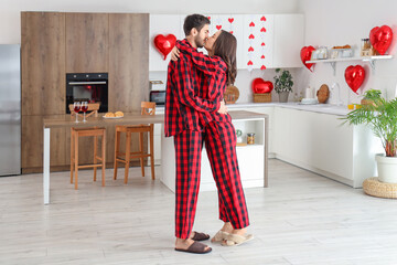 Young couple kissing in kitchen on Valentine's Day