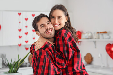 Happy young couple hugging in kitchen on Valentine's Day