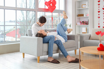 Happy young couple resting at home on Valentine's Day - obrazy, fototapety, plakaty