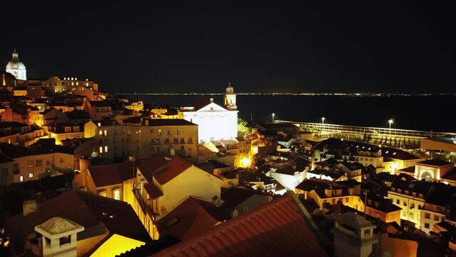 Lisbon, Portugal, panning timelapse at night over the cityscape from the Miradouro das Portas do Sol observation deck.