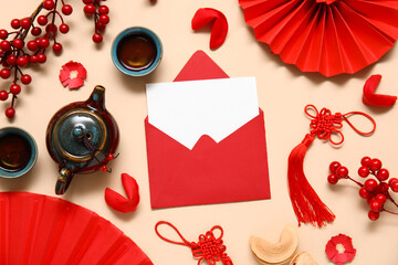 Envelope with blank card, fortune cookies, teapot and Chinese symbols on beige background. New Year...