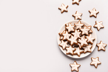 Plate with star-shaped gingerbread cookies on grey background