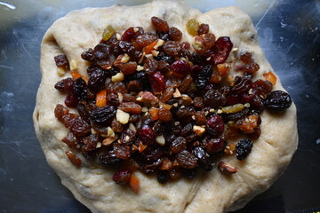 Dried fruit mix and nut soaked in rum on rolled bread dough. Stollen preparation.