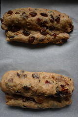 Bread dough with dried fruit mix on a baking tray. Stollen shape.