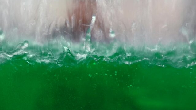industrial background with a transparent reservoir being filled with liquid. Media. Water drops falling down and making ripples.