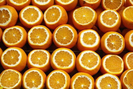 Vibrant image of a pile of freshly harvested oranges, with several slices cut off