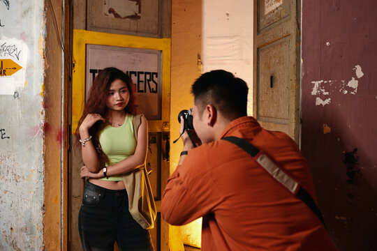 Photographer asking model to pose at old door