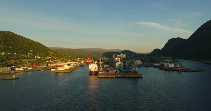 Aerial view of ship docking at industrial park in Mosjoen, Norway. Midnight Sun light.