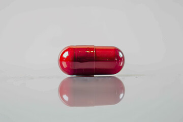 One pill on white background. Medicinal treatment