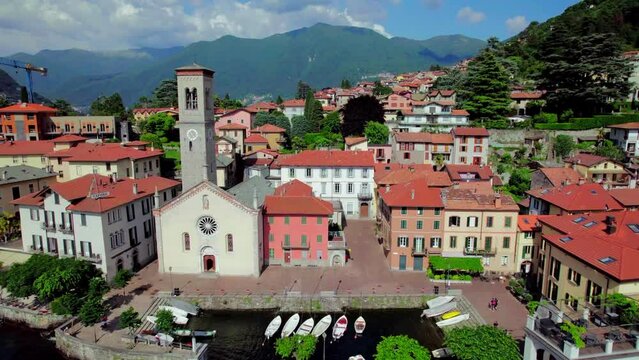 Tourist boat docked at Torno establishing aerial toward a church, Italy