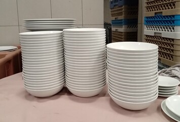 Stack of ceramic bowls in restaurant kitchen.
