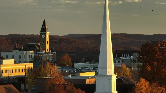 Steeple Of Central United Methodist Church In Fayetteville, Arkansas. Historic Washington County Courthouse Clock Tower In Background. aerial closeup