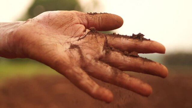 Beautiful image of hands delicately handling red earth, showcasing a connection with the vibrant and colorful soil in a visually captivating moment.