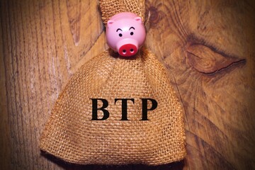 Piggy bank with a text “Btp” translating as Italian government bonds concept of investment .