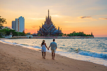 A diverse multiethnic couple of men and women visit The Sanctuary of Truth wooden temple in Pattaya...