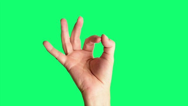 Close up shot of a male hand holding up a classic ok or perfect sign, against a greenscreen background ideal for chroma keying