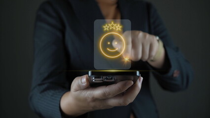 Businessman using smartphone for select smiley face icon for client evaluation and customer...