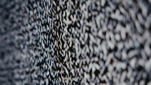 Digital static on a television screen.  Shallow depth of field with wracking focus.
