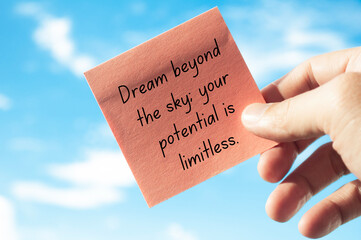 Motivational quote about dreaming beyond the sky on sticky note with sky background. Motivational...