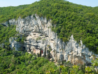 hermitage nestled in the middle of the rock in the mountain without people with green trees