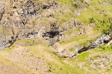 The barren rocky mountains in the middle of the countryside , Europe, France, Occitanie, Hautes-Pyrenees, in summer on a sunny day.