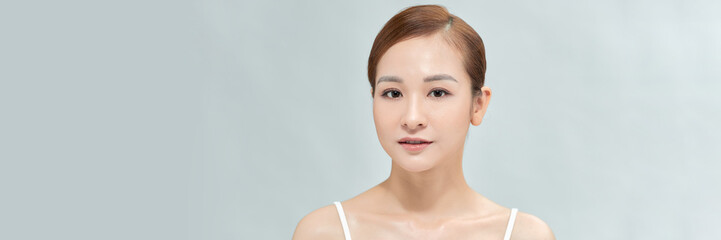 Fototapeta premium Banner with happy Asian female face with natural skin on white background