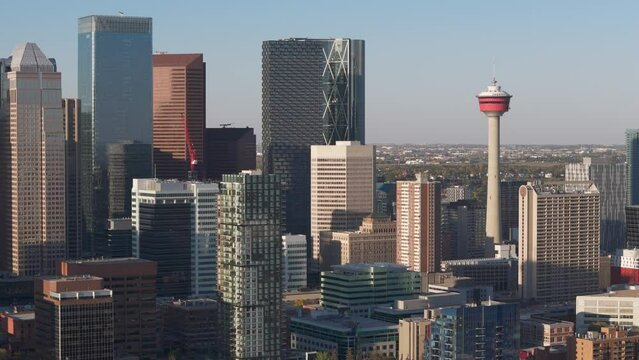 Calgary's large downtown buildings along with the Calgary tower dwarf smaller apartment buildings as seen from an aerial drone point of view