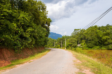 A road crosses mountains and traditional villages , in Asia, in Vietnam, in Tonkin, towards Hanoi, in Mai Chau, in summer, on a cloudy day.