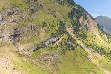 The barren rocky mountains in the middle of the countryside , Europe, France, Occitanie, Hautes-Pyrenees, in summer on a sunny day.