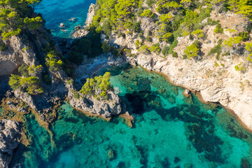 The rocky and green coast, in Europe, in Greece, in Epirus, towards Igoumenitsa, by the Ionian Sea, in summer, on a sunny day.