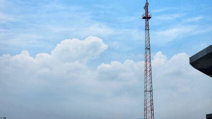 Telecommunication tower with blue sky and white cloud background. Communication concept.
