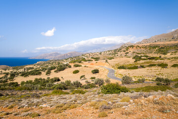 Fototapeta na wymiar The arid rocky coast and its green countryside, in Europe, Greece, Crete, towards Matala, By the Mediterranean Sea, in summer, on a sunny day.