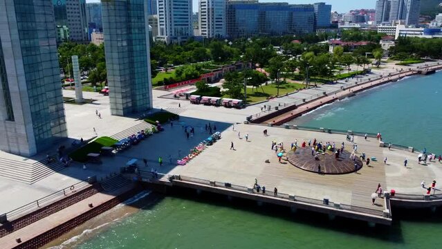 Aerial view of Weihai Xingfu Park pier with people standing on monument with ancient writings, China