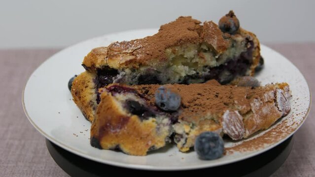 cupcake with berries and cinnamon slice of delicious homemade freshly baked bluberry crumble cheesecake in white ceramic plate on wooden table.