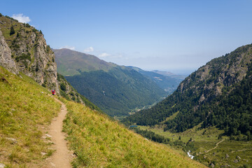 A hiking path in the green countryside , in Europe, in France, Occitanie, in the Hautes-Pyrenees, in summer, on a sunny day.