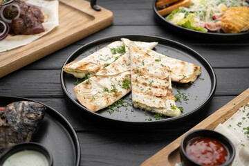 Grilled suluguni pita bread is served on the table in a restaurant. Various dishes of Caucasian cuisine