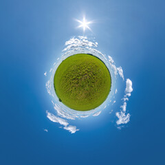 green tiny planet in evening blue sky with beautiful clouds. Transformation of spherical panorama...