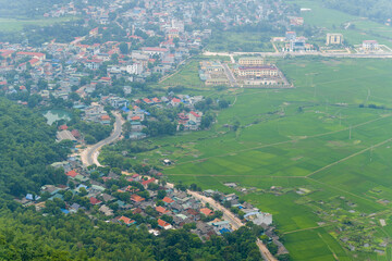 A panoramic view of the city and the green countryside among the mountains, in Asia, Vietnam, Tonkin, towards Hanoi, Mai Chau, in summer, on a cloudy day.