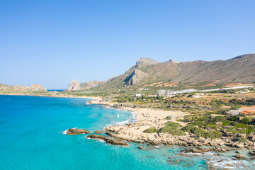 Fototapeta na wymiar The sandy beach at the foot of the rocky cliffs in the arid countryside , in Europe, Greece, Crete, towards Kissamos, towards Chania, By the Mediterranean Sea, in summer, on a sunny day.