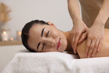 Fototapeta na wymiar Woman receiving back massage on couch in spa salon